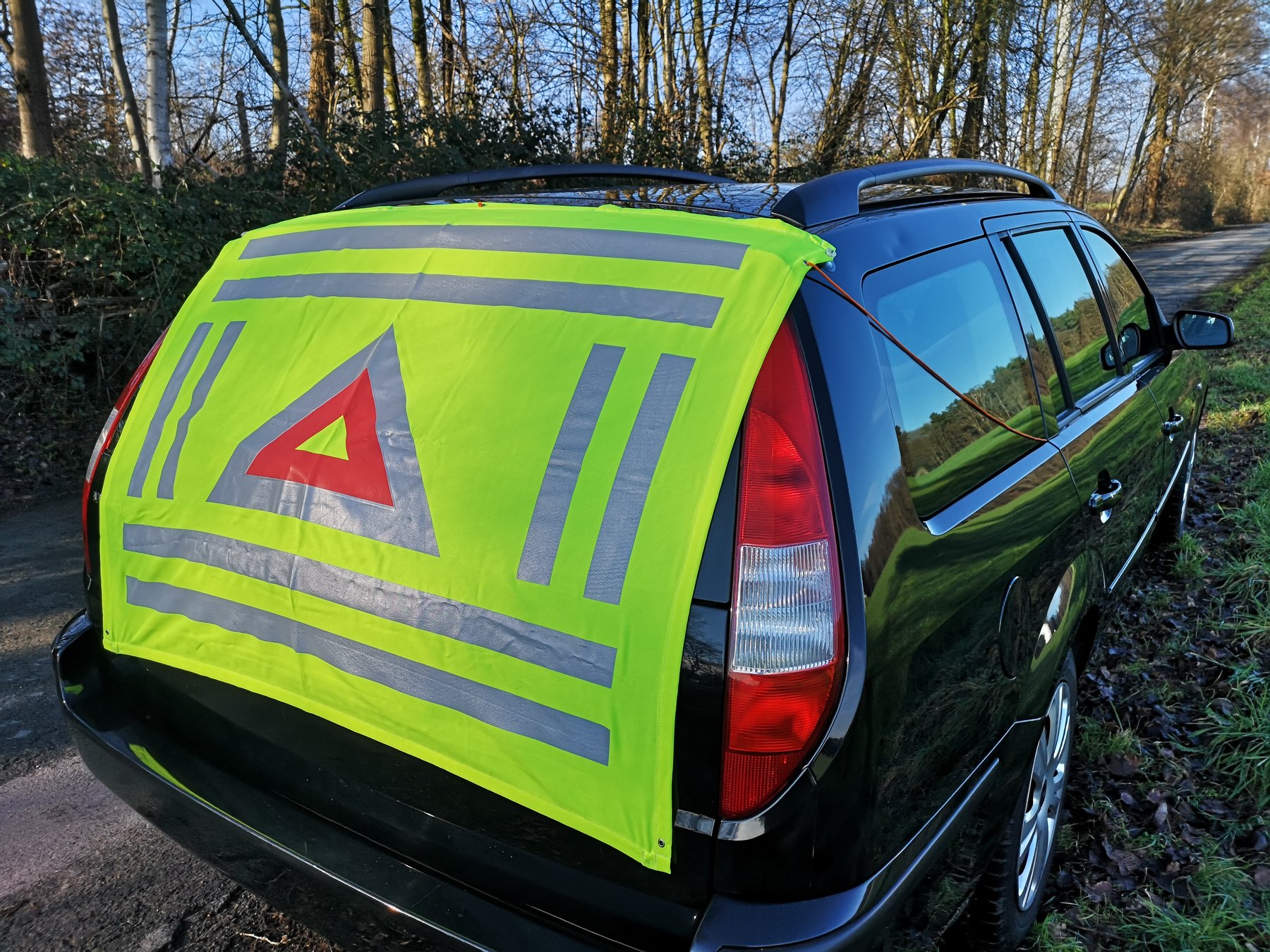 KFZ-Warndecke mit Sicherungsseil am Fahrzeug befestigt
